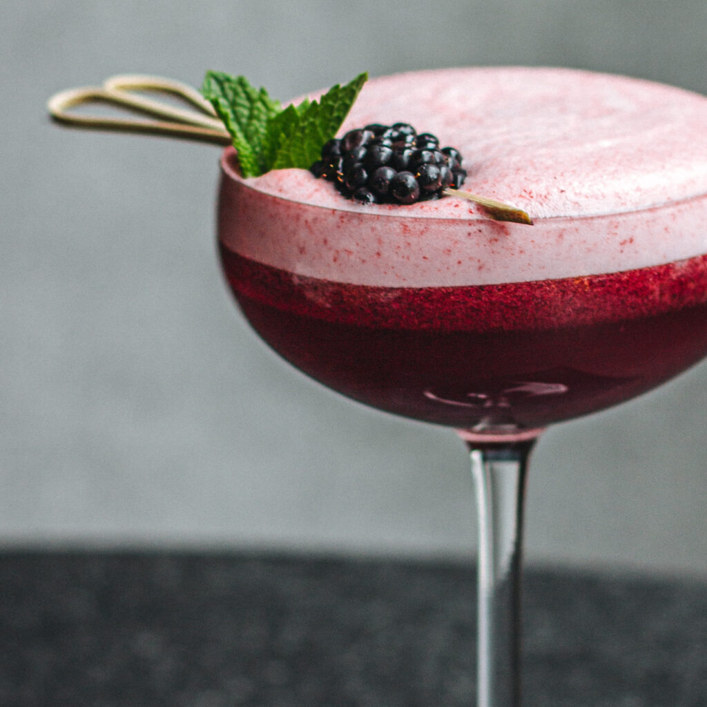 Photograph of red cocktail with blackberry