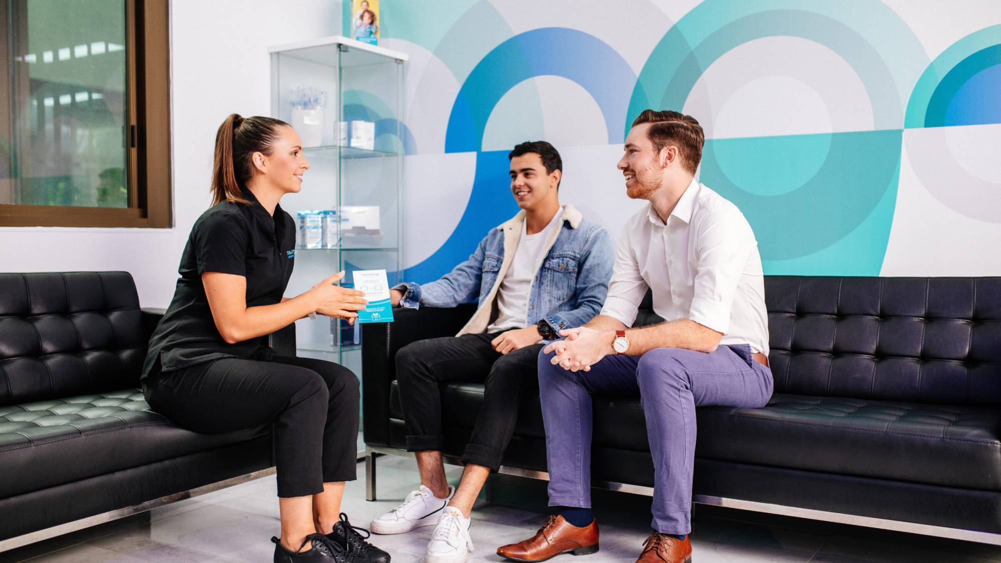 Toowong Orthodontics photography staff member engaging with two young male patients
